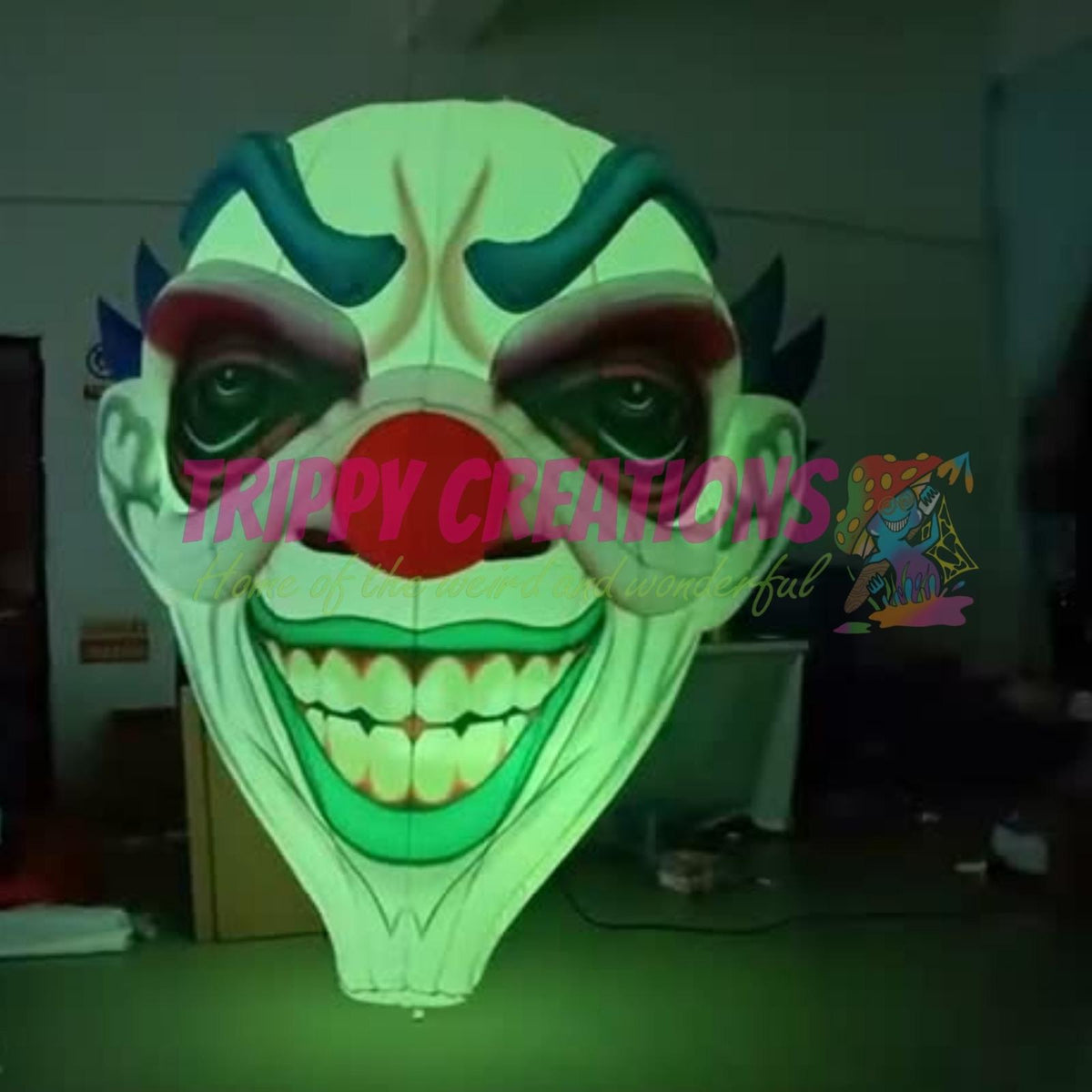 Giant LED inflatable clown face glowing green in low light, showing its sinister grin for fright night décor.
