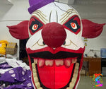 Evil clown inflatables with red hair and eerie expressions, set up inside a dark party venue.