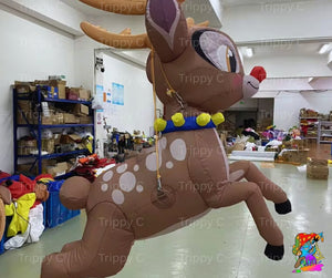 Inflatable reindeer decoration in a warehouse setting with shelves and various items in the background.