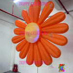 Trippy Creations giant orange inflatable daisy flower decoration with LED lights, made of polyester taffeta.