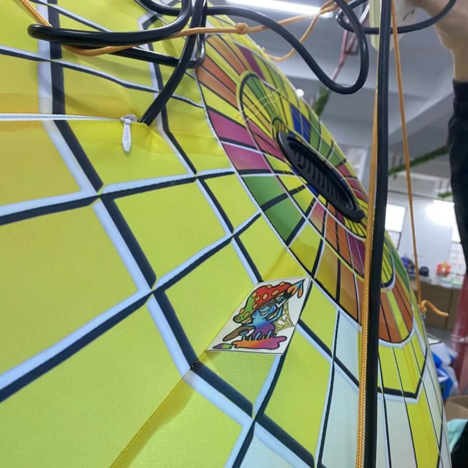 Trippy Creations giant inflatable disco ball decoration with yellow grid pattern and colorful stained glass design.