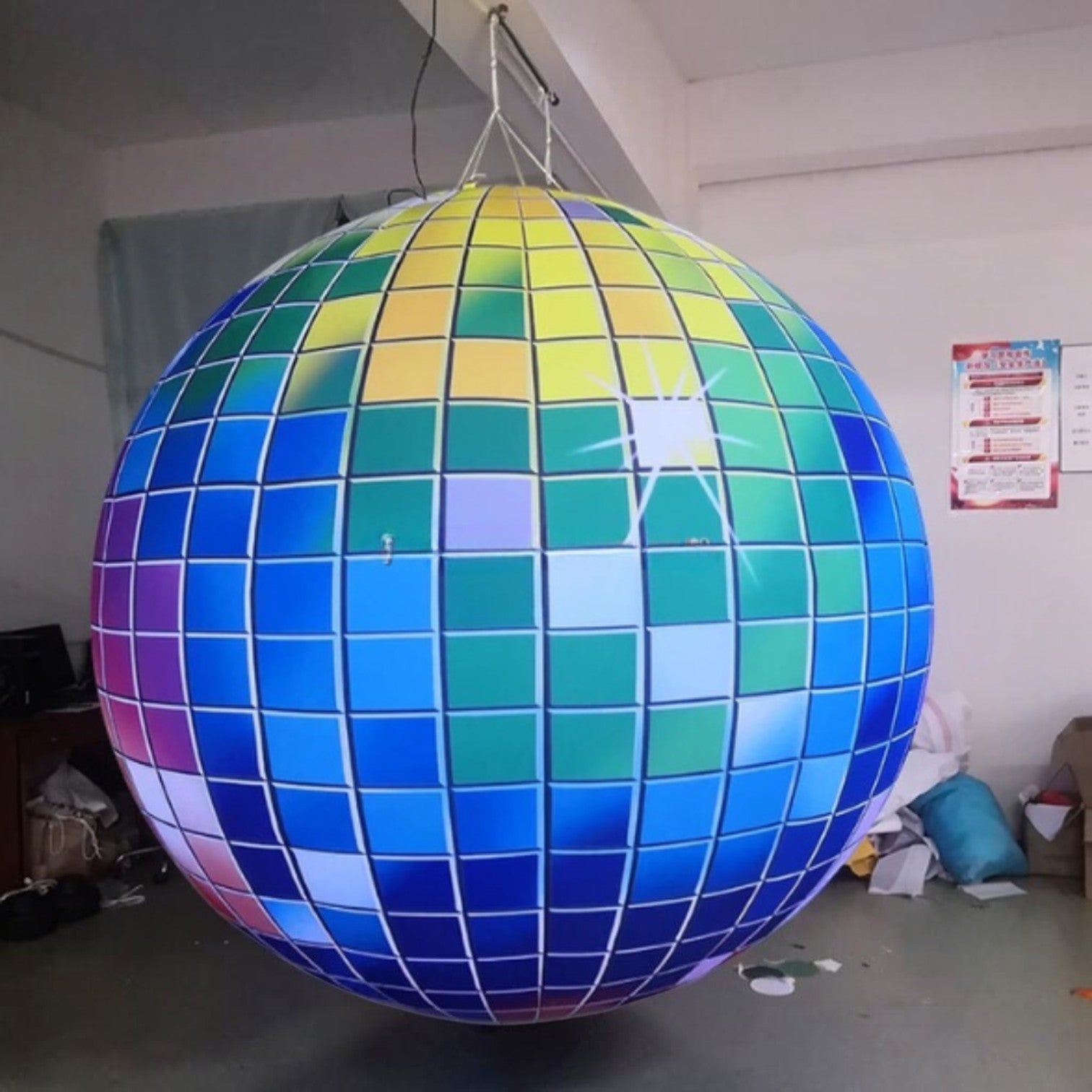 Trippy Creations giant inflatable disco ball decoration with LED lights, featuring a colorful mosaic pattern of blue, green, yellow, and purple squares.