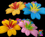 Trippy Creations giant inflatable flowers in yellow, blue, pink, and purple with red and green accents. Whimsical decor for parties.