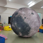 Trippy Creations giant inflatable moon decoration with realistic craters and surface details, illuminated from within.