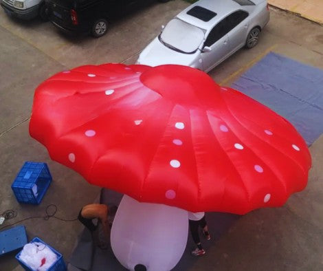 Trippy Creations giant red and white inflatable mushroom party decoration. Features a large red cap with white polka dots and a white stem.