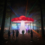 Trippy Creations giant red and white inflatable mushroom party decoration with LED lights, set at an outdoor night event with lasers and a crowd.