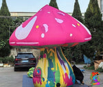 Trippy Creations giant pink fairy mushroom inflatable decoration with white spots and a colorful psychedelic stem.