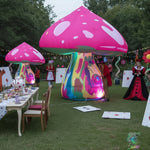 Trippy Creations giant pink inflatable mushroom with white spots, illuminated psychedelic stem, at an Alice in Wonderland themed party.