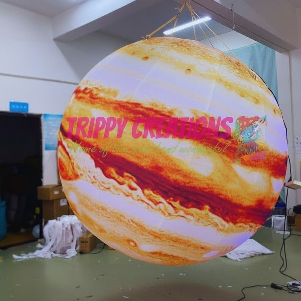 Trippy Creations giant inflatable Jupiter planet with swirling orange and white bands, ideal for space-themed events.