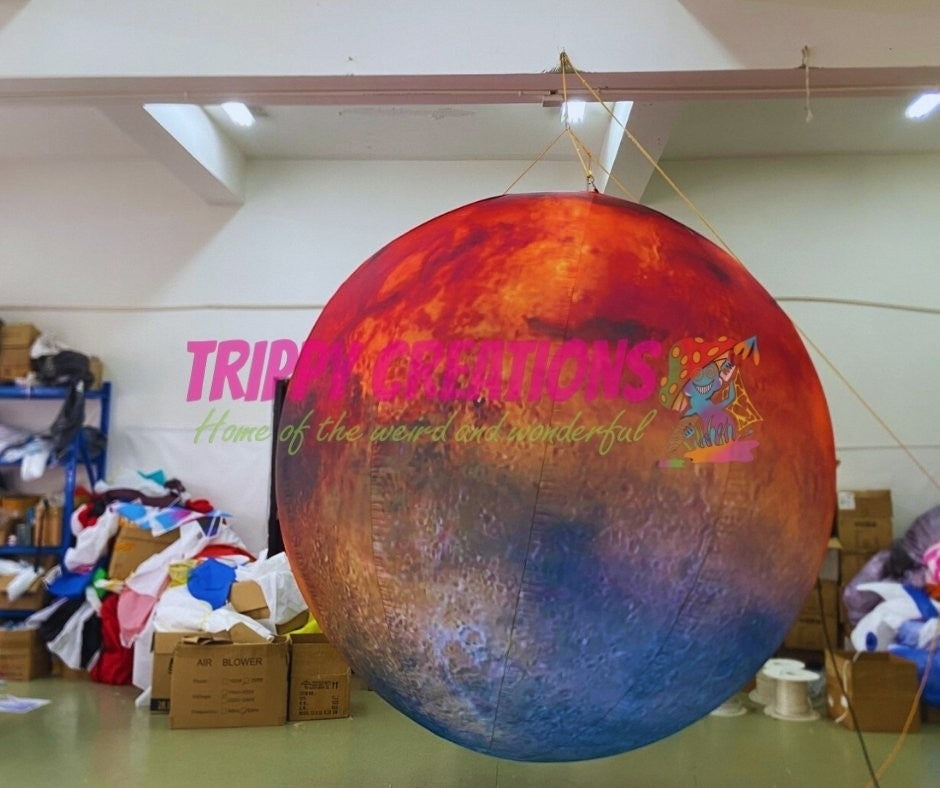 Trippy Creations inflatable Mars planet, red and blue hues, designed for hanging installations at space-themed events.