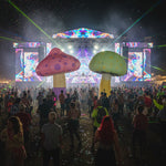Trippy Creations inflatable mushrooms in pink with purple spots and green with yellow spots, perfect for whimsical events.
