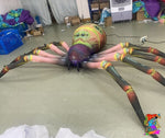 Trippy Creations giant inflatable spider decoration with pink legs and green eyes, perfect for Halloween events.