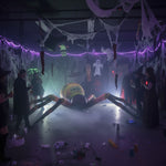 Trippy Creations giant inflatable spider decoration with yellow, orange, and black details, set up for a Halloween party.