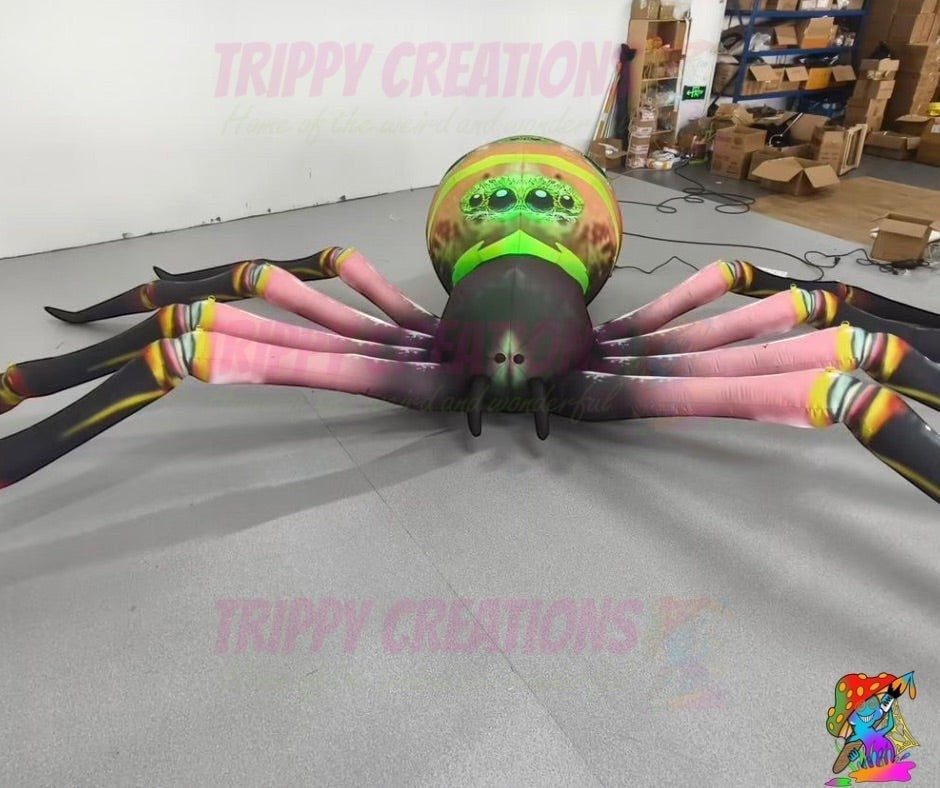 Trippy Creations giant inflatable spider decoration with pink legs and green eyes, perfect for Halloween events.