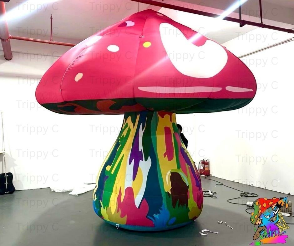 Trippy Creations giant pink fairy mushroom inflatable with white spots on cap and colorful psychedelic stem. Oxford fabric.