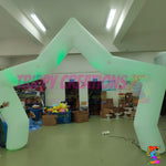 White inflatable LED star arch photographed indoors, showing the sculpted star outline and floor-standing design.